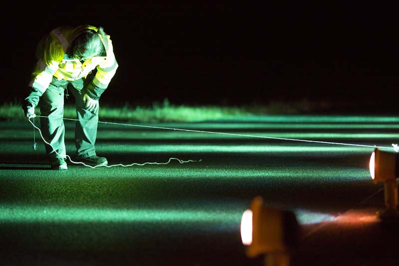 agent effectuant des mesures de nuit sur piste